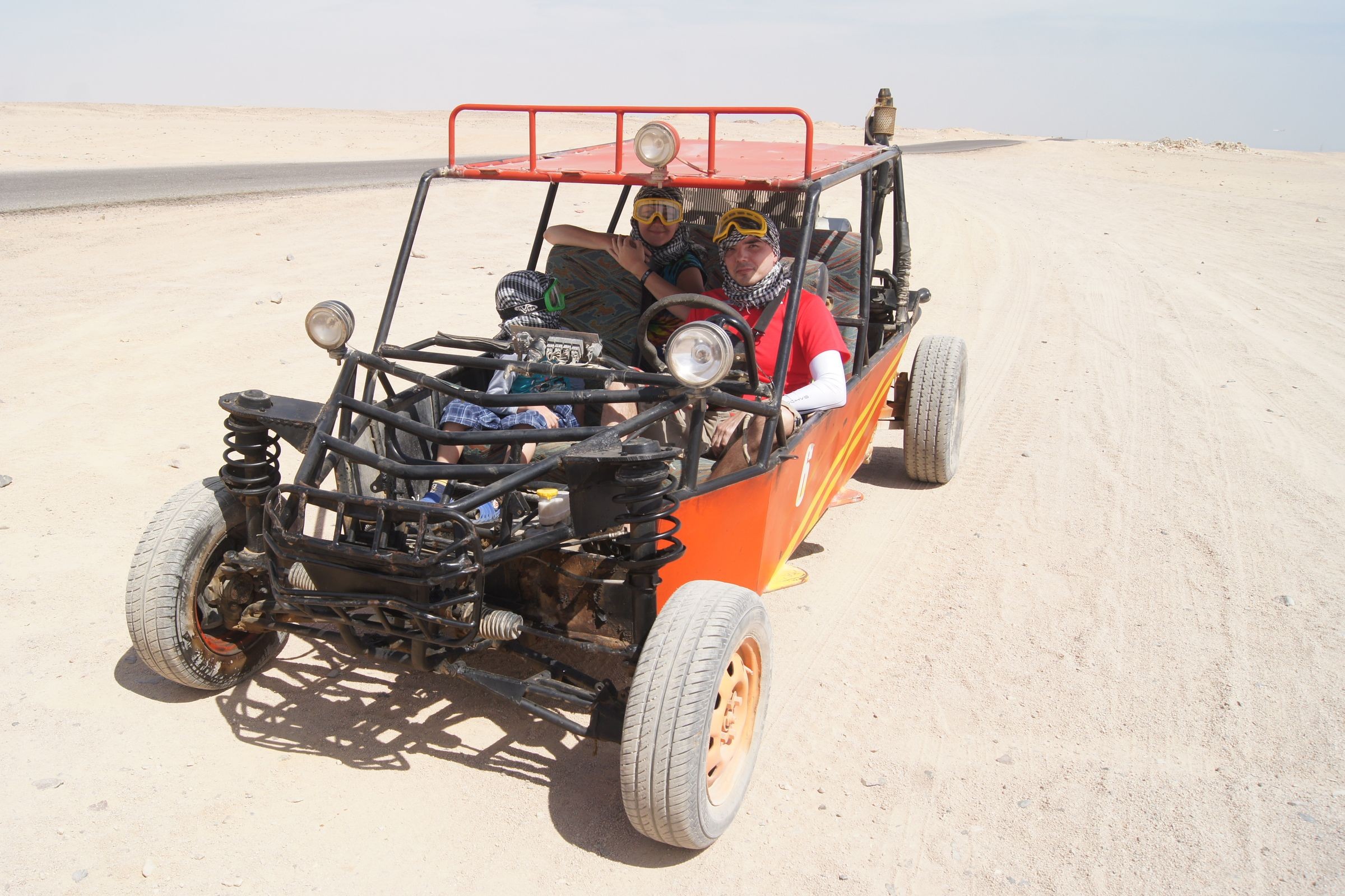 Open buggies on a sandy desert track.