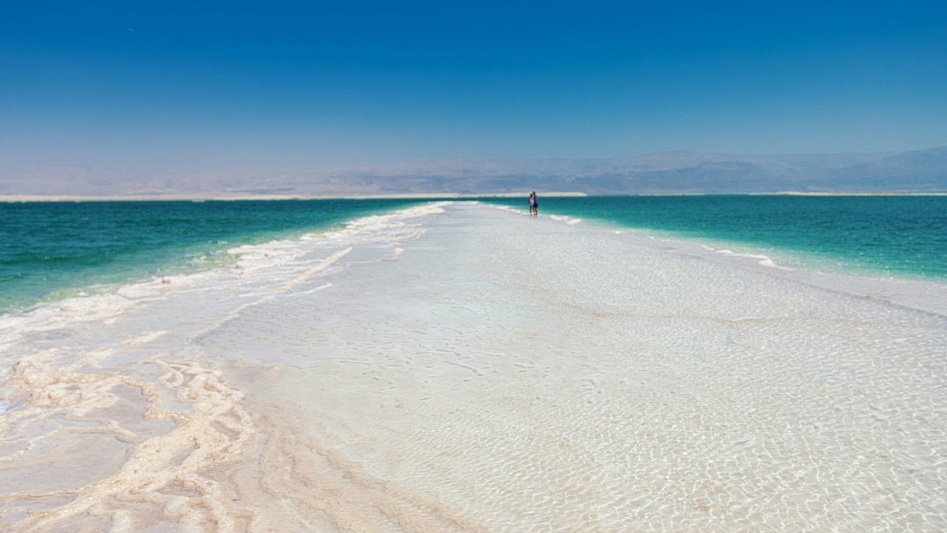 Salt formations and turquoise waters along the Dead Sea shoreline in Jordan