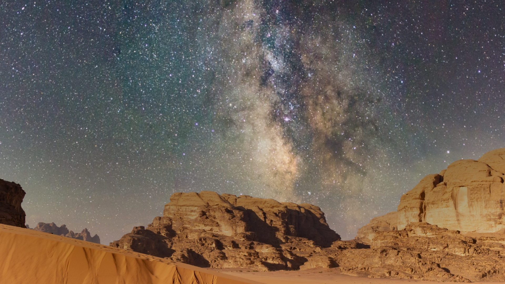 Milky Way over the sand dunes and rock formations of Wadi Rum desert in Jordan