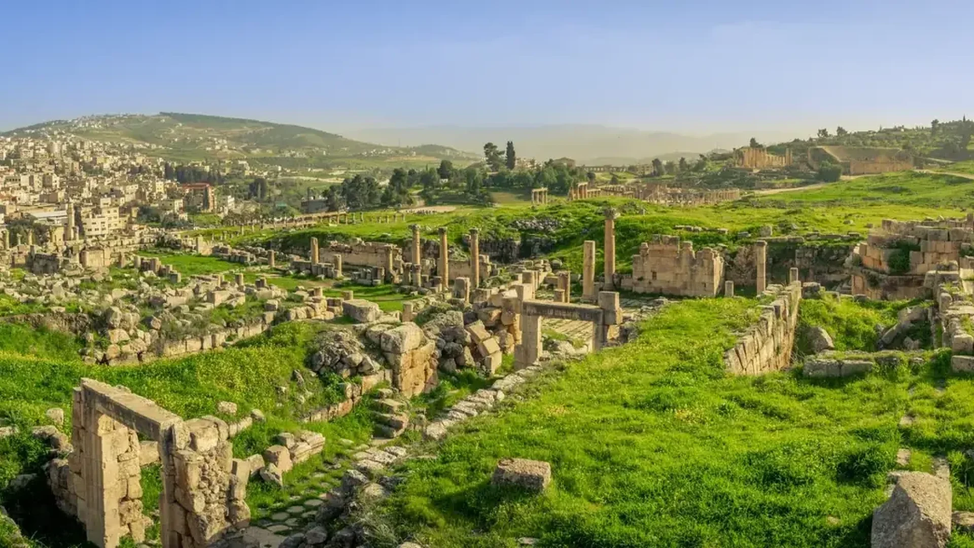 Ancient Roman ruins of Jerash surrounded by green hills in Jordan