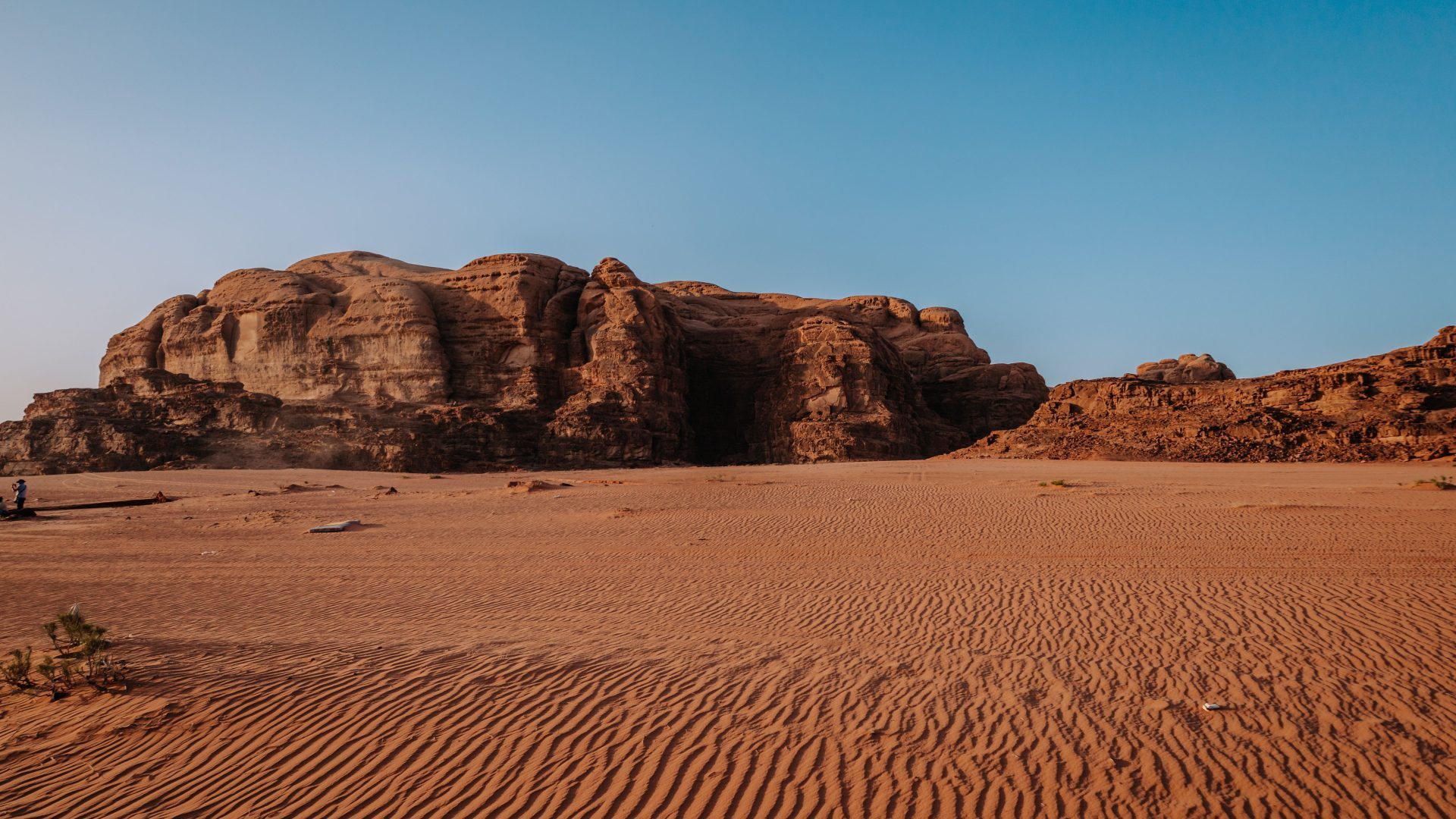 Wadi Rum desert landscape with red sand dunes and towering sandstone mountains in Jordan