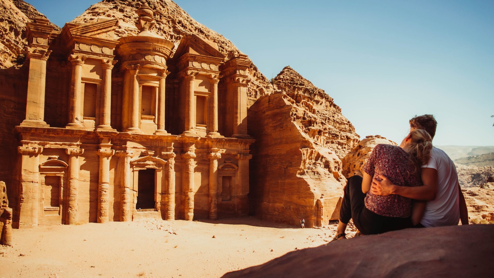 The Monastery at Petra with a couple overlooking the ancient rock-carved monument in Jordan