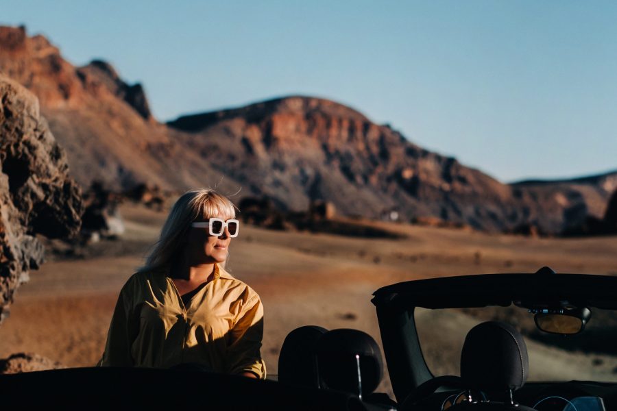 Traveler on a road trip by convertible car in the Jordanian desert