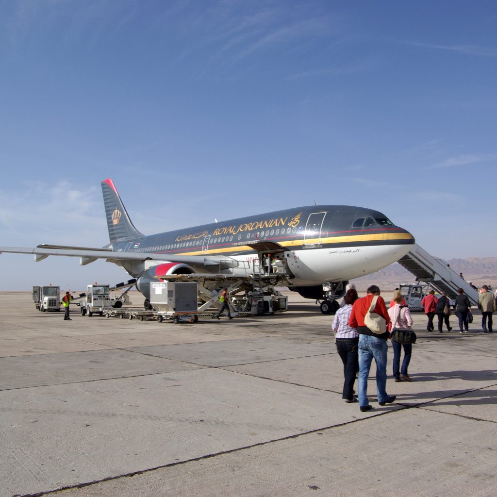 Royal Jordanian aircraft with passengers boarding at an airport in Jordan