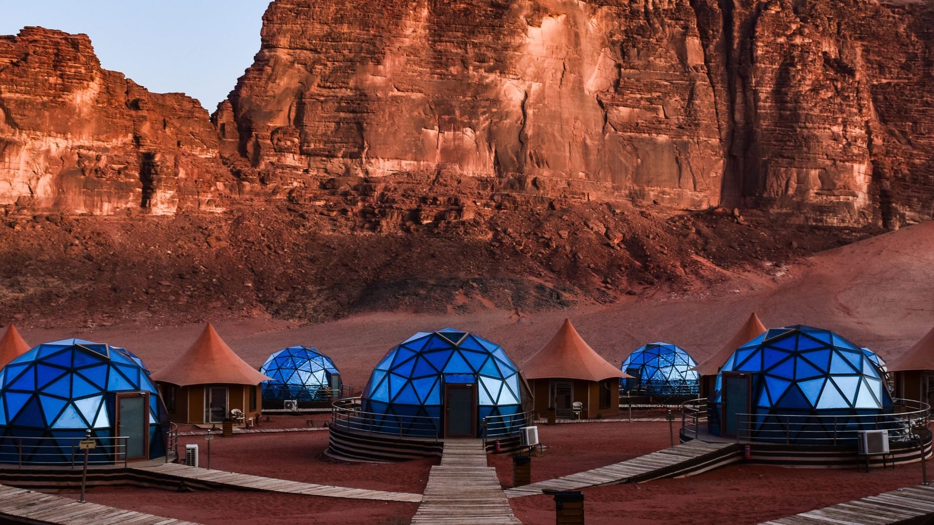 Luxury bubble tents at a desert camp in Wadi Rum, Jordan, surrounded by dramatic red sandstone mountains